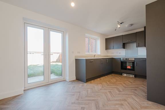 A kitchen with a wooden floor and a window.