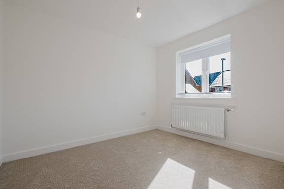 A room with a window and a radiator on the floor.