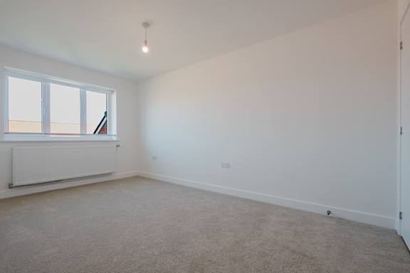 A room with a window and a radiator on the wall.