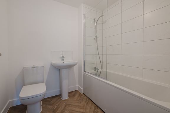 A white toilet sits next to a sink in a bathroom.