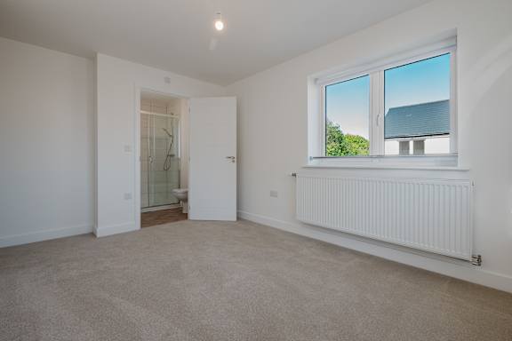 A room with a window, a door, and a radiator.