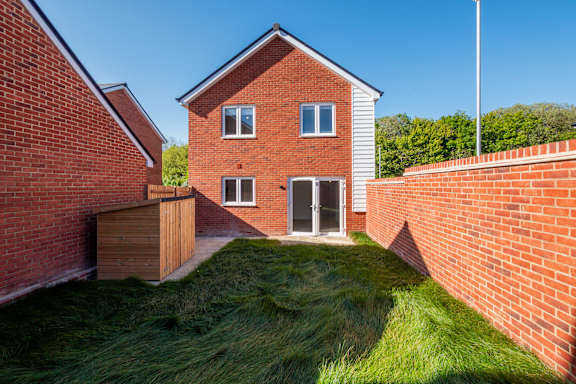 A red brick house with a green lawn in front.