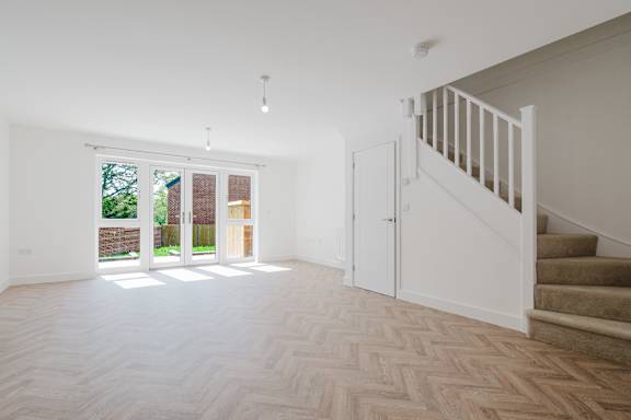 A room with a staircase and a window with a view of a garden.