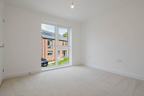 A white room with a window overlooking a street.