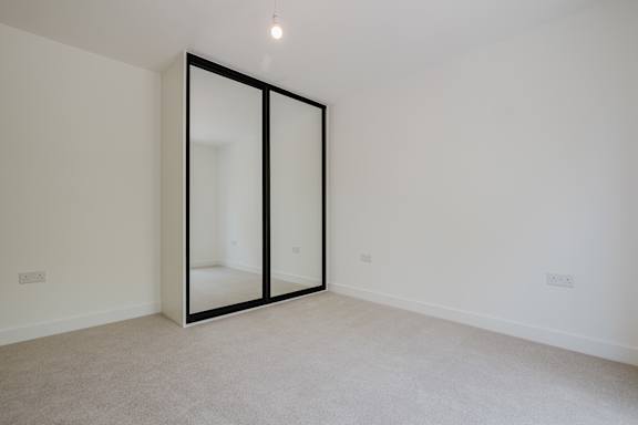 A room with a sliding door and carpeted floor.