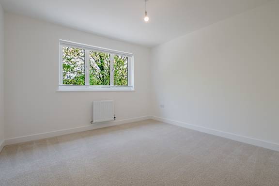 A room with a window and a radiator on the wall.