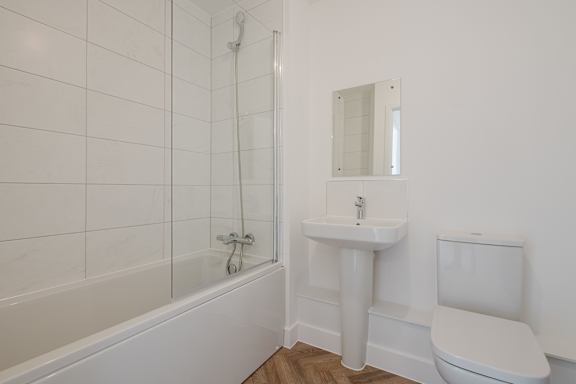 A white bathroom with a sink, toilet and bathtub.