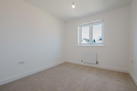 A room with a window and a radiator on the wall.
