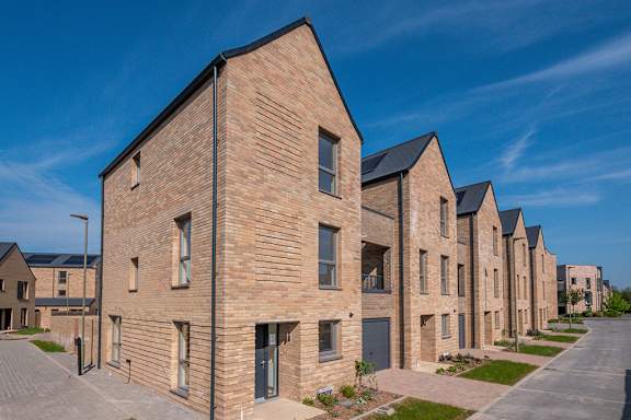 A row of new houses with brick facades and pitched roofs.