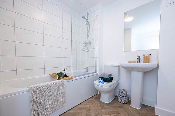 A white bathroom with a white tub, toilet, and sink.