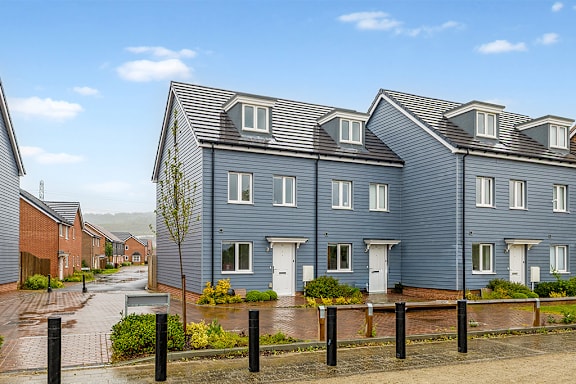 A row of houses with a blue sky in the background.