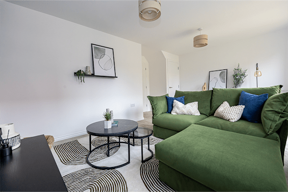 A living room with a green couch and a black coffee table.