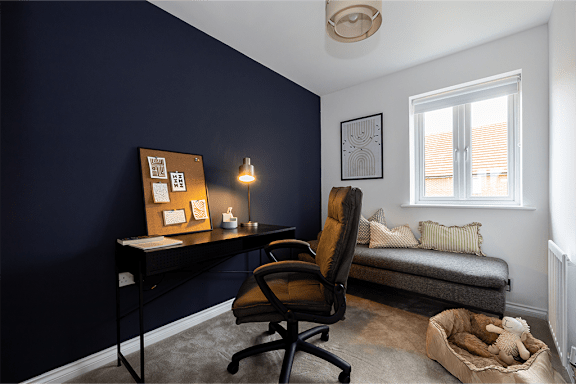 A room with a desk, chair, and a window.