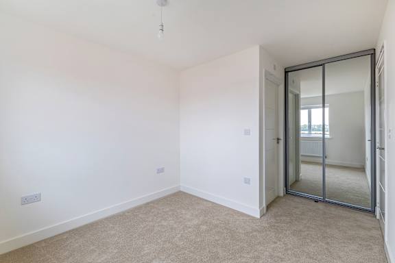 A room with a carpeted floor and a sliding glass door.
