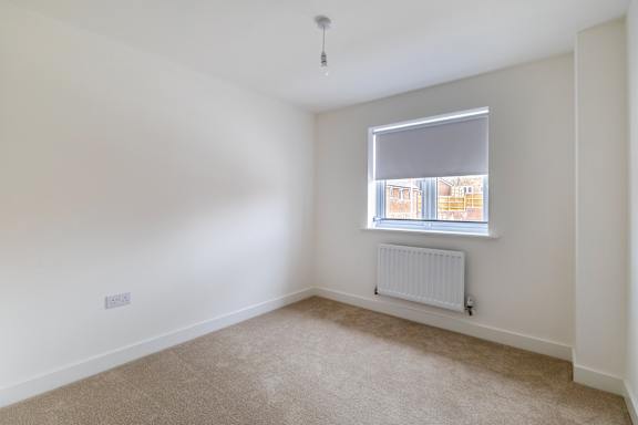 A room with a window and a radiator on the floor.