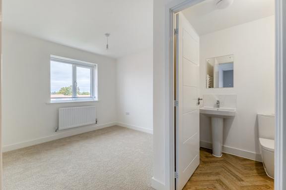 A white bathroom with a window and a sink.