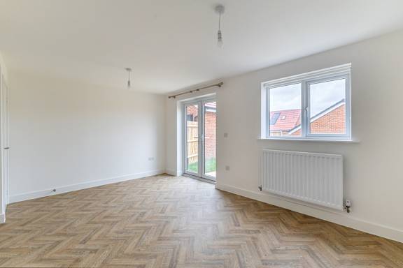 A room with a wooden floor and a window.