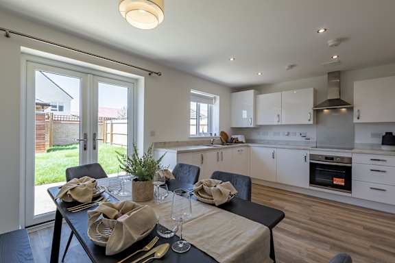 A modern dining room with a table set for two.