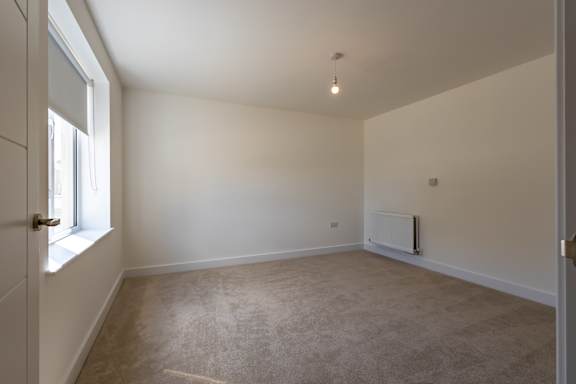 A room with a window and a radiator on the wall.