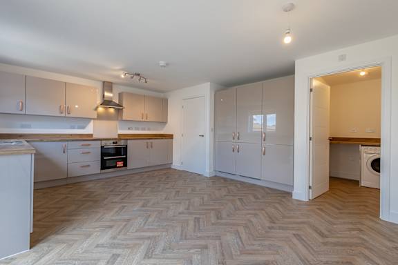 A kitchen with a washing machine in the corner.