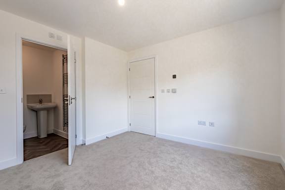 A white room with a carpeted floor and two doors.