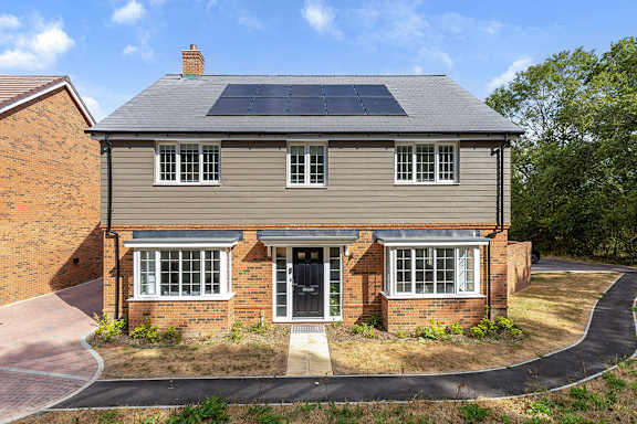 A house with a grey roof and solar panels on the roof.