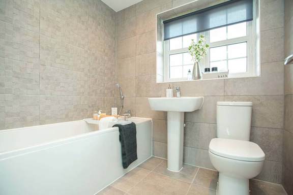 A bathroom with a tub, toilet, and sink.