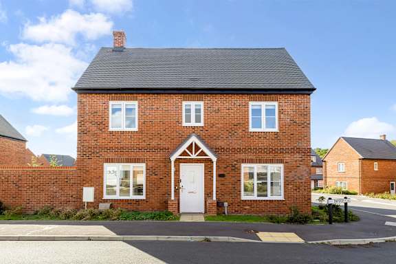 A red brick house with a white door and windows.