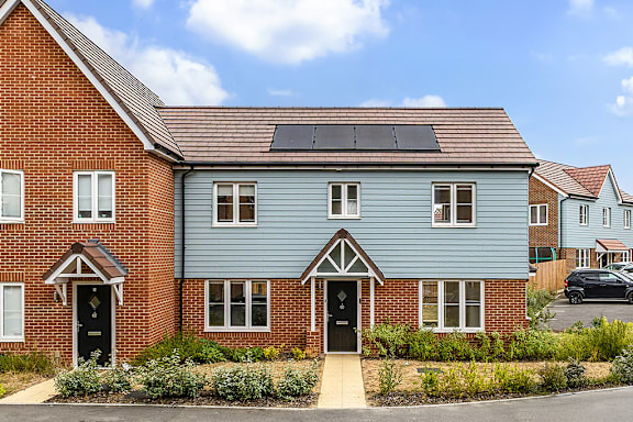 A house with a blue front and solar panels on the roof.