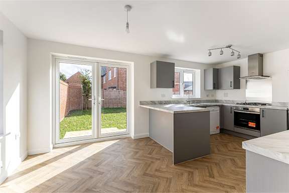 A kitchen with a wooden floor and a white ceiling.