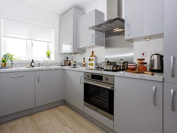 A modern kitchen with white cabinets and stainless steel appliances.