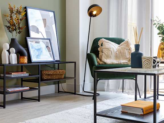 A living room with a green chair, a table with a lamp, and a book titled "Love".