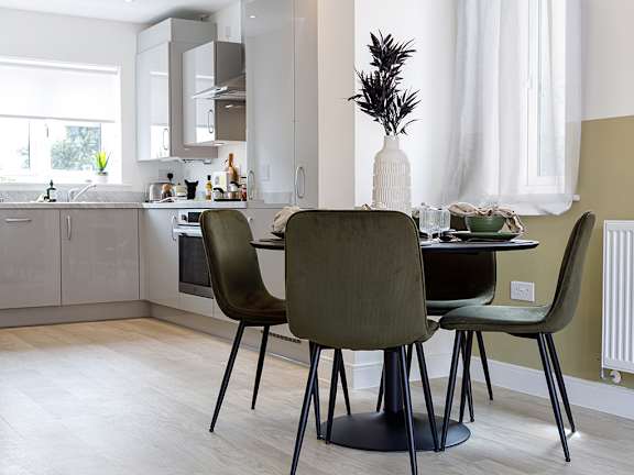A modern kitchen with a dining table and chairs.