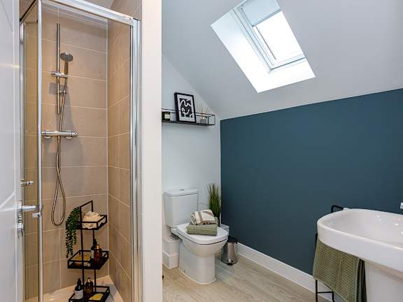 A bathroom with a toilet, sink, and shower.