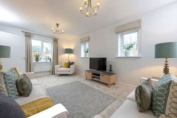 A living room with a grey rug and a white sofa.
