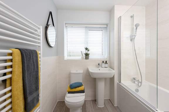 A bathroom with a toilet, sink, and shower.