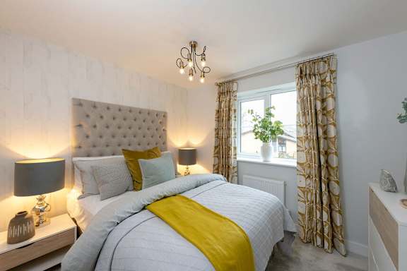 A bedroom with a bed, nightstands, and a window.