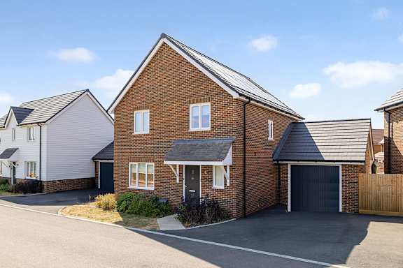 A house with a grey garage door and a black roof.