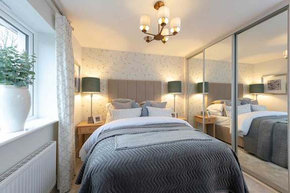 A bedroom with a large bed and a chandelier.