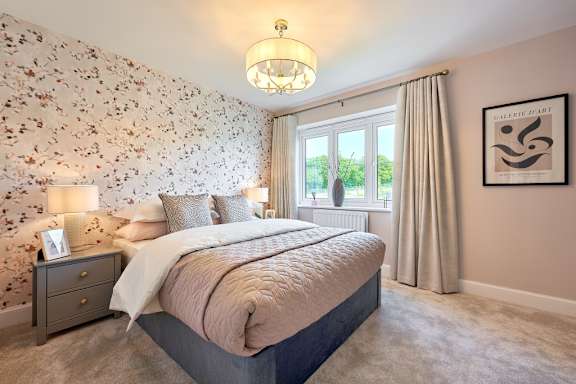 A bedroom with a floral wallpaper and a large bed.