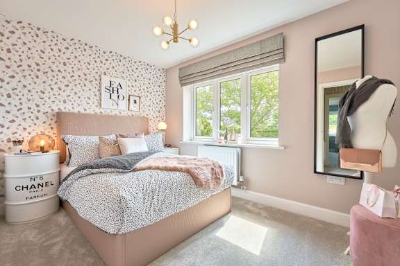 A bedroom with a bed, a mirror, and a window.