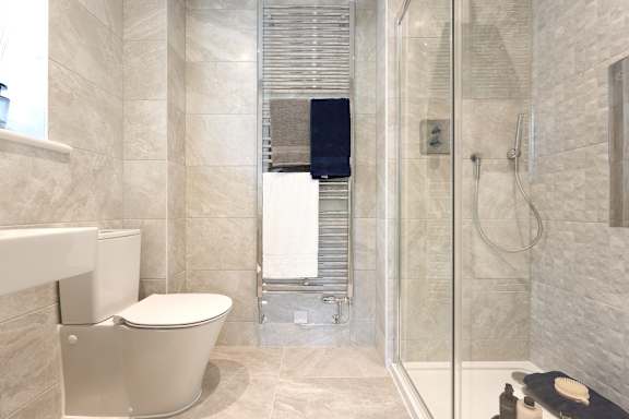 A bathroom with a toilet, a shower, and a sink.