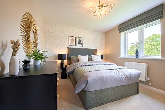 A bedroom with a large bed and a chandelier.