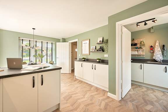 A kitchen with a laptop on the counter.