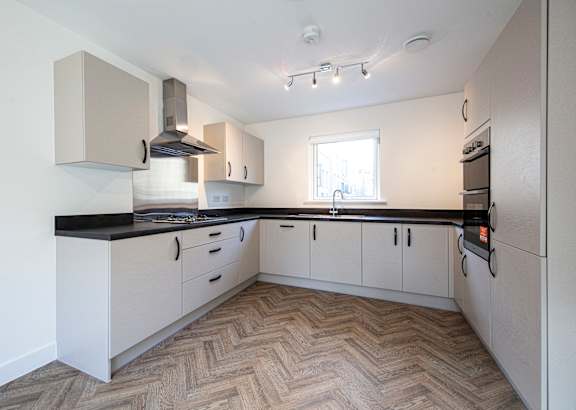 A kitchen with a black counter top and white cabinets.