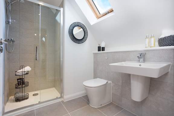 A bathroom with a toilet, sink, and shower.