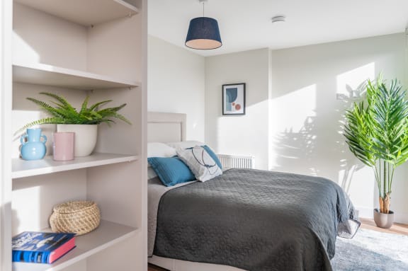 a bedroom with a bed and a potted plant