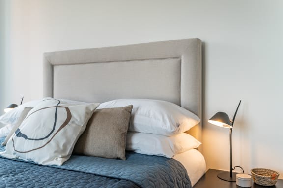 a bedroom with a bed and pillows and a lamp