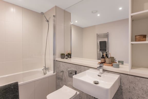 a white bathroom with a sink and a shower and a toilet