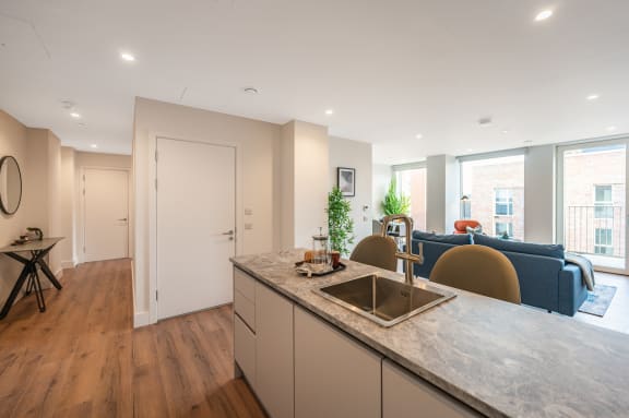 a kitchen with an island and a living room with a blue couch